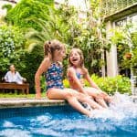 Two girls splashing feet in pool