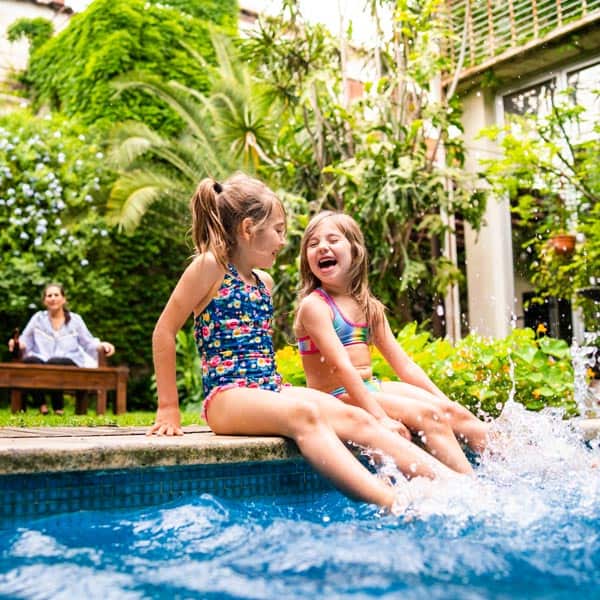 Two girls splashing feet in pool